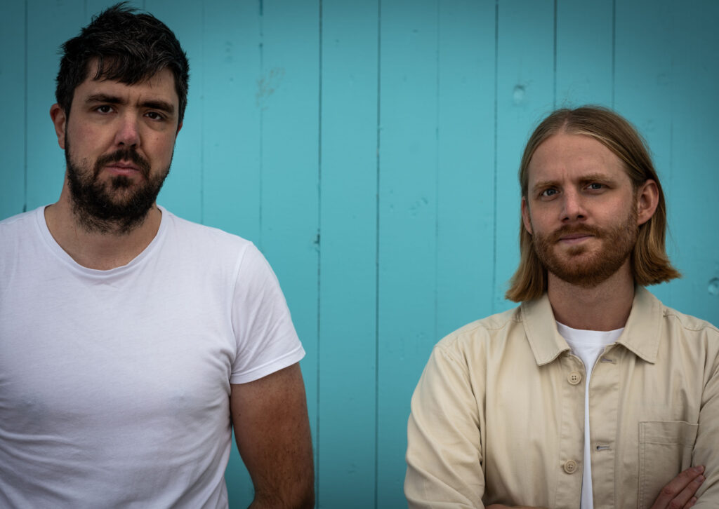 Days Canon members standing in front of teal wooden house.